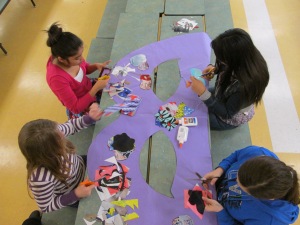 Student Council members work on a large masquerade mask that will serve as the photo booth backdrop at Thursday's dance.